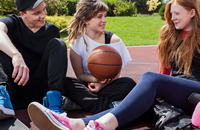 Drei Freunde auf dem Sportplatz mit einem Basketball