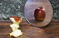 Apfel vor dem Spiegel als Symbol für Anorexie