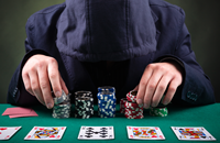 Ein junger Mann mit verstecktem Gesicht spielt Glücksspiele