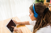 Junge Frau hört Musik mit einem Tablet und mit Kopfhörern